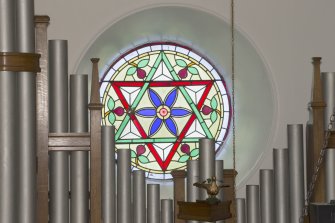 Interior. Detail of round stained glass window to centre of south wall
