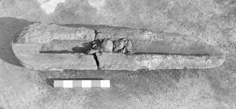 The eroded sectioned breech end of an iron gun, after cleaning. A quadrant of metal has been cut from the breech end to reveal the chamber profile (1974). The iron ball is in place, as is the hemp wadding on either side of it. Scale in inches.