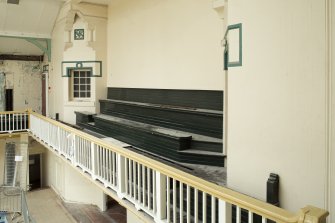 Interior. View of tiered seating on end balcony of pool hall.