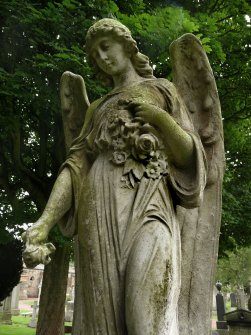 Detail of a monumental statue of an angel holding roses, in the Grange Cemetery, Edinburgh.