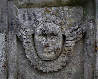 Detail of relief showing the face and wings of an angel, heavily eroded. Liberton Cemetery, Edinburgh.