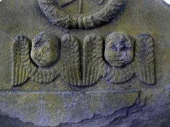 Detail of relief showing the faces and wings of two angels, with wreath above. The Howff Burial Ground, Dundee.