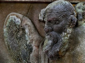 Detail of relief of male angel covered in moss, Old Calton Burial Ground, Edinburgh.