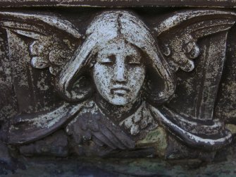 Detail of relief showing the head and wings of an angel, New Dean Cemetery, Edinburgh.