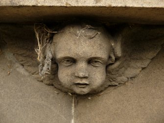 Detail of relief showing the head and wings of an angel, Saint Cuthbert's Cemetery, Edinburgh.