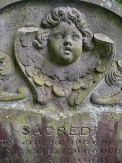 Detail of relief showing the head and wings of an angel on a headstone, The Howff Burial Ground, Dundee.