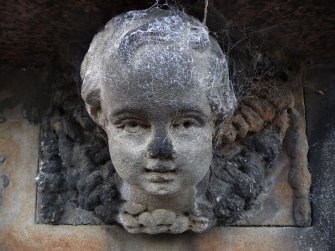 Detail of headstone with face of an angel depicted in haut relief and wings in bas relief on background. Canongate Kirk Cemetery, Edinburgh.