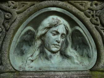 Detail of relief showing the face and wings of an angel, New Dean Cemetery, Edinburgh.