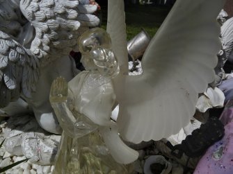 Detail showing a glass statue of an angel in prayer, Rosebank Cemetery, Edinburgh.