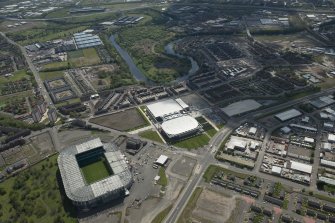 Oblique aerial view of the construction of the Glasgow Commonwealth games site with Parkhead in the foreground, looking to the SSE.