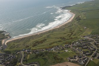 General oblique aerial view of Cruden bay centred on Cruden Bay Golf Courses, looking to the SSE.