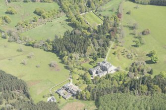 General oblique aerial view of Cluny Castle estate with adjacent stable blocks, looking to the E.