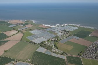 General oblique aerial view of Carlingheugh Bay centred on Seaton House, looking to the SE.