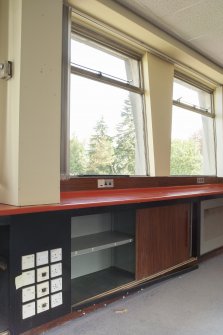 Interior. Detail of underwindow workbench and storage.