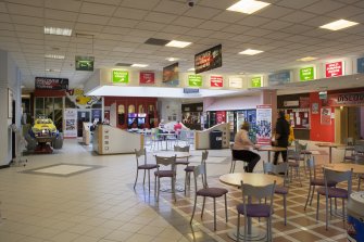 Interior. View from West across entrance/central concourse, showing glazed lightwell and signage.