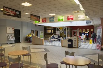 Interior. View from South West across entrance/central concourse, showing glazed lightwell and signage.