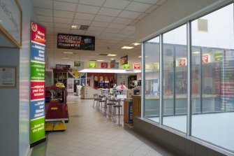 Interior. View from West across central concourse, showing glazed lightwells and signage.