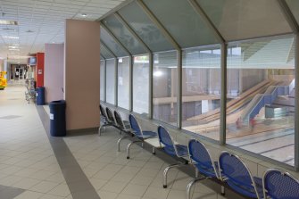 Interior. View from West of long central corridor, showing spectators area for swimming pool