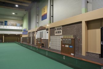 Interior. Oblique view looking along the west wall of the carpet bowls green, showing score boards and lockers.