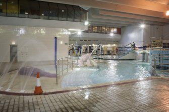 Interior. View looking north east within the swimming pool hall, with dance studio to left and viewing area of main concourse to right at upper level.