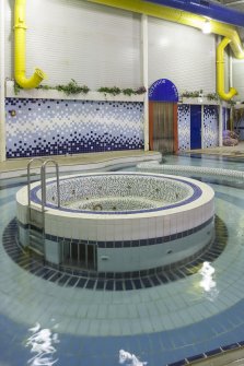 Interior. View of jacuzzi and pool, with former entrance to outdoor pool beyond, within swimming pool extension.
