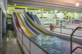 Interior. View looking south along water slides within swimming pool hall.
