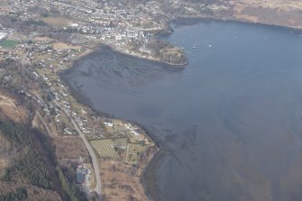 General oblique aerial view of the remains of the kelp grids and fish traps in Loch Portree with Portree beyond, looking to the NNE.