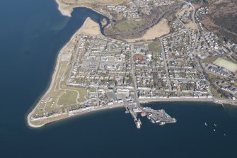 Oblique aerial view of Ullapool with the piers in the foreground, looking NNW.