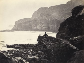 Wide view of rock formations, including figure, on the beach of Kilchattan, Colonsay.
Titled: '141. Behind Kilchattan, Colonsay.'
PHOTOGRAPH ALBUM NO 186: J B MACKENZIE ALBUMS vol.1