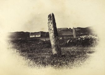 View of the two standing stones, originally thought to have been part of a stone circle known as "Fingal's Limpet Hammers," at Lower Kilchattan, Colonsay.
Titled: '30. Pillar Stones at Kilchattan, Colonsay.'
PHOTOGRAPH ALBUM NO 186: J B MACKENZIE ALBUMS vol.1