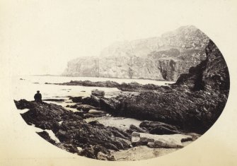 Wide view of rock formations, including figure, on the beach of Kilchattan, Colonsay.
Titled: '83. Rocks behind Kilchattan, Colonsay.'
PHOTOGRAPH ALBUM NO 186: J B MACKENZIE ALBUMS vol.1