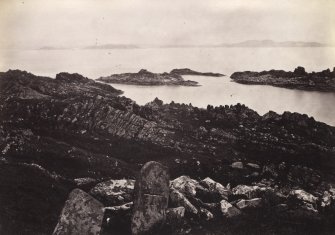View, wide-angle, of ruins at Eileach An Naoimh, Argyll. There is an incised cross-slab in the foreground.
Titled: '46. On Ealan Naomh, locally regarded as the tomb of St. Columba's mother.'
PHOTOGRAPH ALBUM, NO 186: J B MACKENZIE ALBUMS vol.1