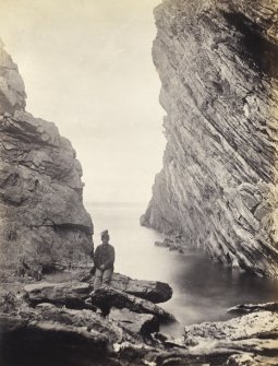 View of rock formations with man in foreground, on the beach of Kilchattan, Colonsay.
Titled: '126. Behind Kilchattan, Colonsay.'
PHOTOGRAPH ALBUM NO 186: J B MACKENZIE ALBUMS vol.1