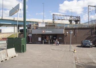 View from west looking to West Street subway station, with the railway above and M74 motorway beyond