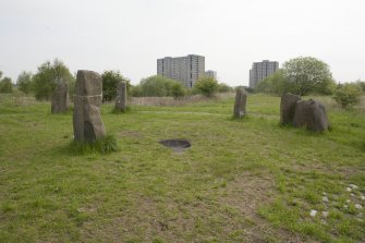 View looking north east past the centre stone and east side of the Sighthill Stone Circle, towards the high rise flats of Pinkston Drive