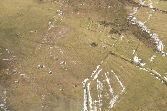 Oblique aerial view of the enclosures, field boundaries and rig, looking SSE.