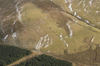 Oblique aerial view of the enclosures, field boundaries and rig, looking SE.