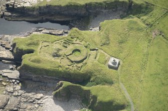 Oblique aerial view of Nybster Broch and Nybster Commemorative Monument, looking SSE.