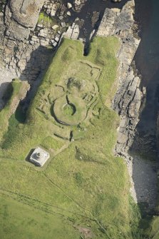 Oblique aerial view of Nybster Broch and Nybster Commemorative Monument, looking NE.