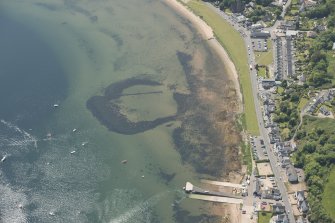 Oblique aerial view of the remains of the harbour and pier, looking to the SSW.