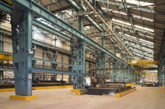 Interior. Central Yard, Steel preparation workshop, West End. General view from South West of North and South BAy (originally 1906) with MG Corta CNC plasma burner right foreground and two MG 3 (CNC Plasma) burning beds to the left. Plasma burners are used to cut or weld metal using a high speed inert gas (such as compressed air). Also note the original 1906 stanchions with integral crane rail. The Crane on the right is a 7.5 Tonne Matterson Electric Overhead Traveller (or EOT, istalled 1995). The two beyond are 5 Ton Arrol EOT (Installed 1996).