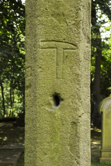 Detail of carved hammer on east face of cross.
