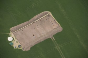 Oblique aerial view of the enclosure under excavation, looking W.