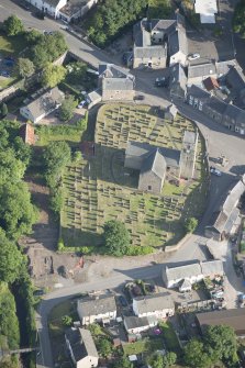 Oblique aerial view of St Serf's Church with the Glasgow University excavations on the edge of the churchyard, looking S.