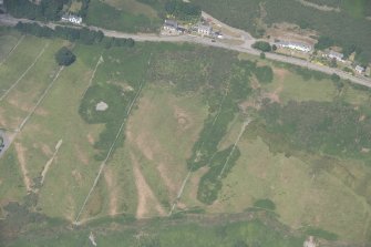 Oblique aerial view centred on the parchmarks of the ring ditch and pits, looking NW.