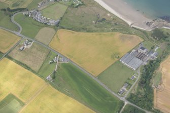 Oblique aerial view of the windmill and cropmarks of the ring ditch at Sandend, looking NNW.