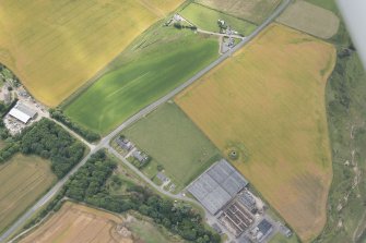 Oblique aerial view of the windmill and cropmarks of the ring ditch at Sandend, looking SW.