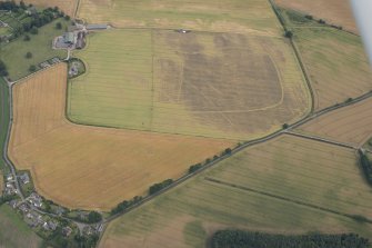 Oblique aerial view of the cropmarks of the cursus, barrows, enclosure and ring ditches, looking SE.