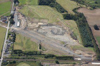 Oblique aerial view of the works and evaluation trenches along the A75 Dunragit Bypass to the SW of Dunragit village, looking S.