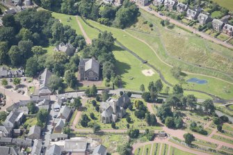 Oblique aerial view centred on the former Moat Park Church, Biggar Church and the Burn Braes, looking WSW.